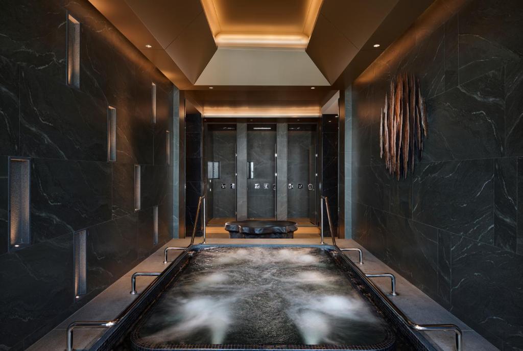 A second view of the bubbling hydrotherapy tub in a dark, softly lit spa room.