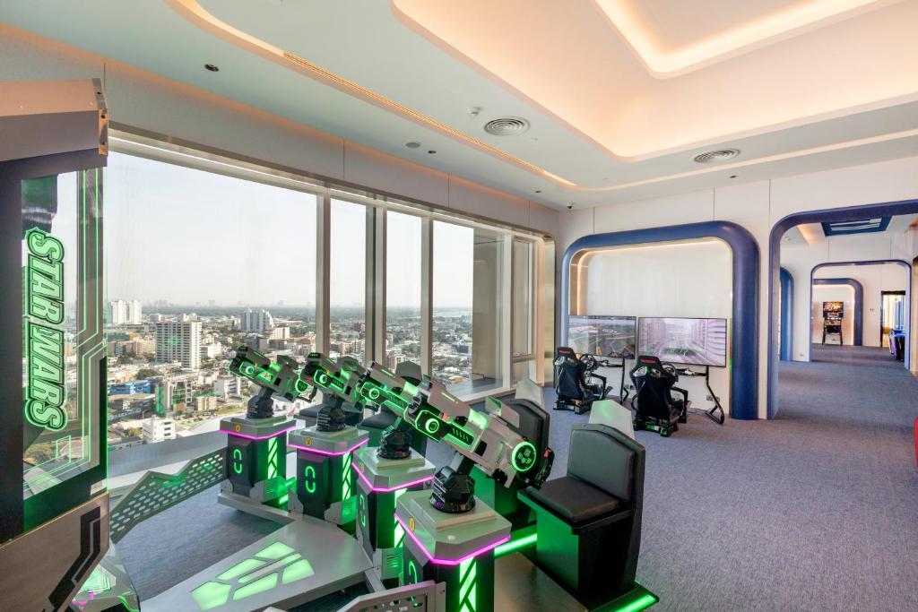 A bright high-floor gym with illuminated strength machines and a broad city view.