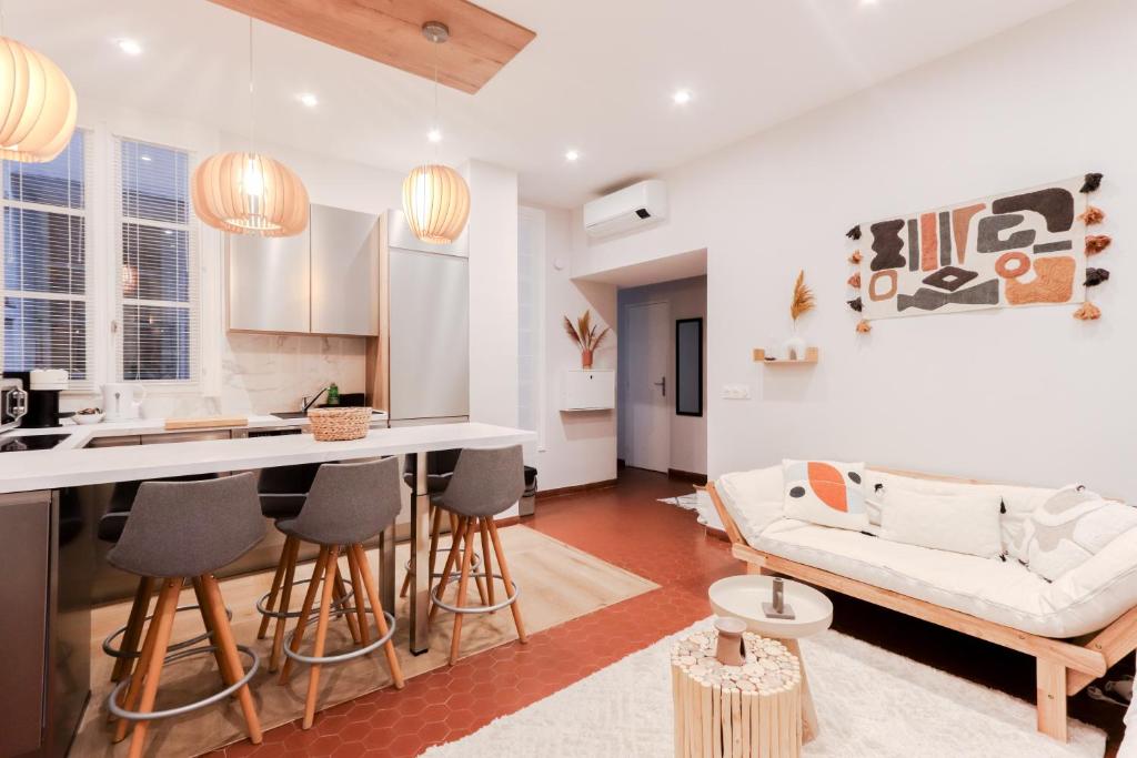 Il comprend une cuisine et un salon avec un bar et un canapé. dans l'établissement Suite Nomade - Vieux Nice - 2 chambres - Wifi - AC - 5 min des plages - 30 min de Cannes et Monaco, à Nice