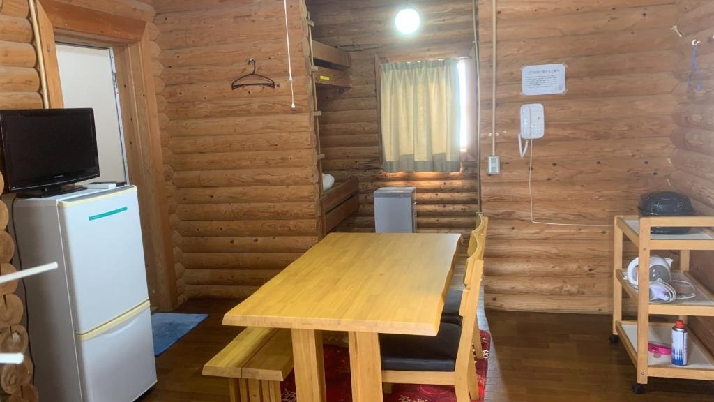a dining room with a wooden table and a refrigerator at Uenodai Midorinomura - Vacation STAY 27833v in Yasugi