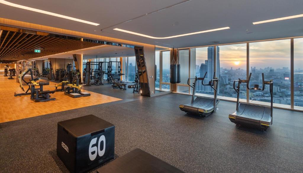 A broad fitness room with functional equipment and sunset-facing cardio machines.