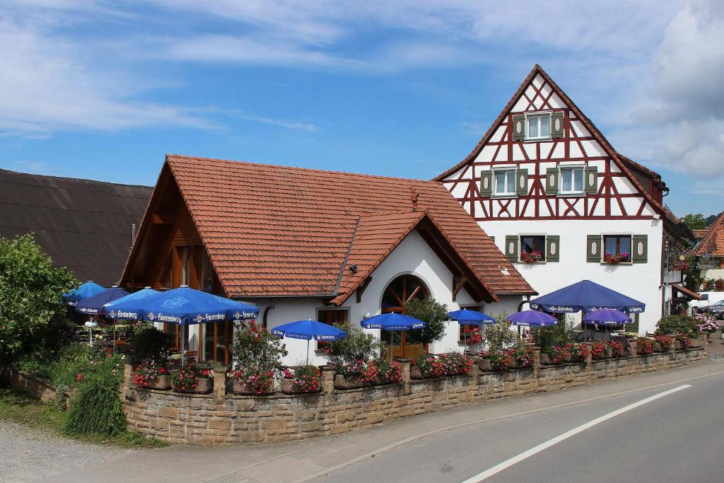 a building with blue umbrellas on the side of a road at Gasthof Adler in Salem