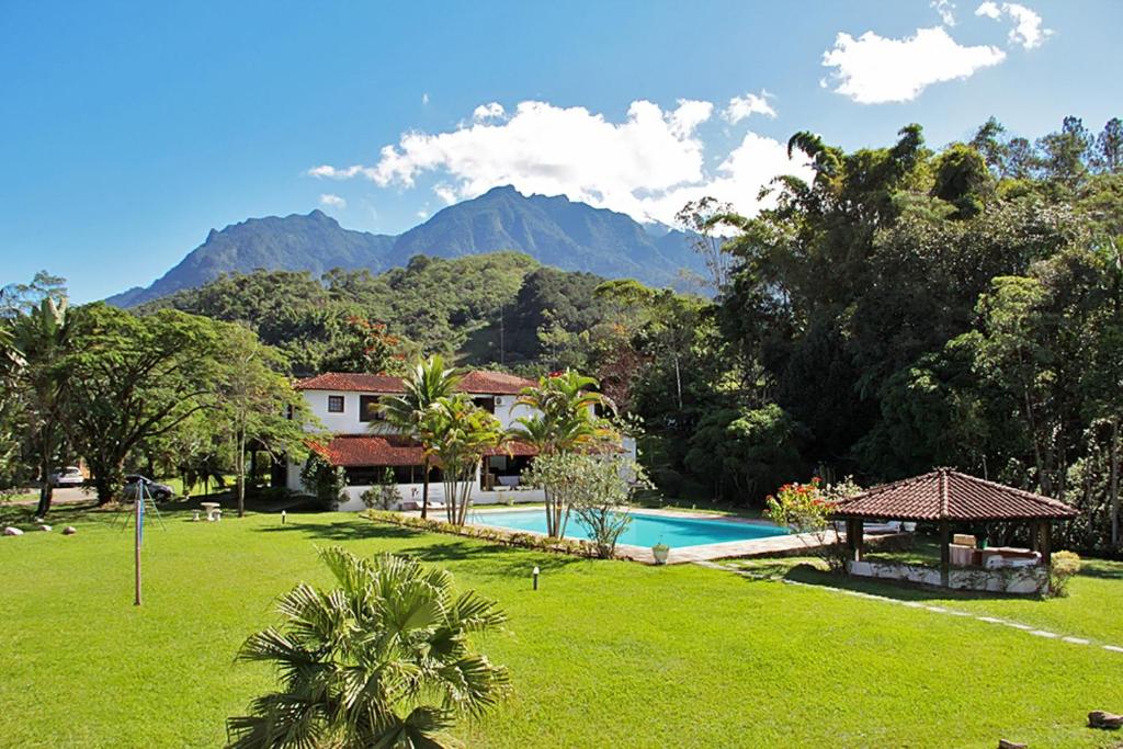 un complejo con piscina y montañas de fondo en Aconchegos Ile de France, en Penedo