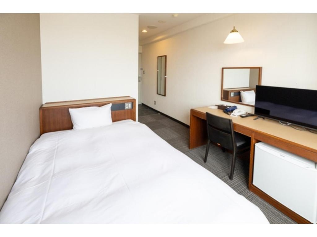 a room with a bed and a desk with a computer at Hotel Taiyo Noen Saijo - Vacation STAY 26756v in Saijo