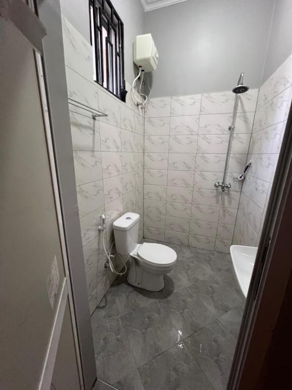 ein Badezimmer mit Toilette und Waschbecken in der Unterkunft Nana Apartment in Marombosa