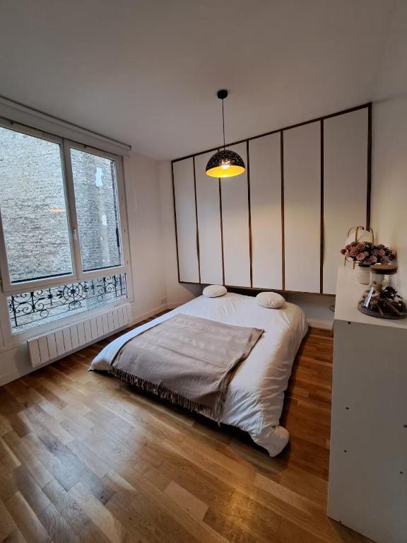 une chambre avec un lit et une grande fenêtre dans l'établissement A 5 minutes de la place de la nation, Studio, Paris, Rive Gauche, à Paris
