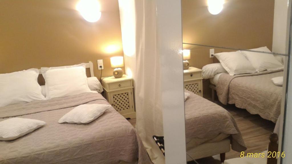 a hotel room with two beds and a mirror at Chez Cécile in Mornas
