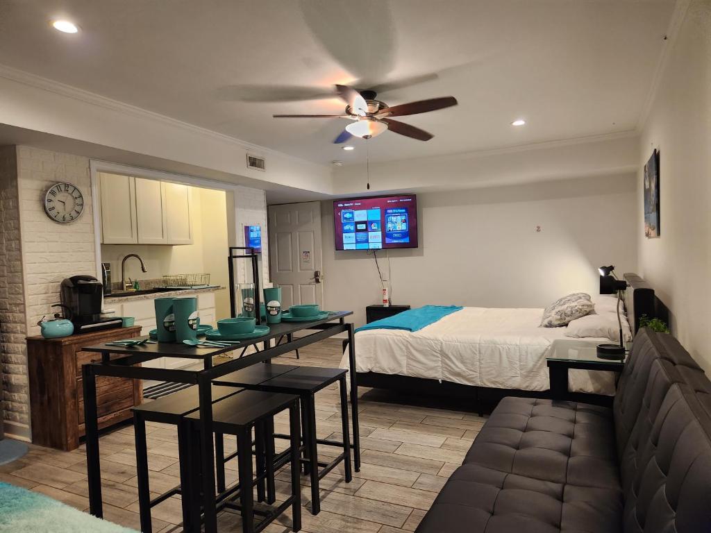 a bedroom with a bed and a table and a ceiling fan at King Bed Exec Suite Hot Tub, Gym, Grill & Laundry in Kernersville