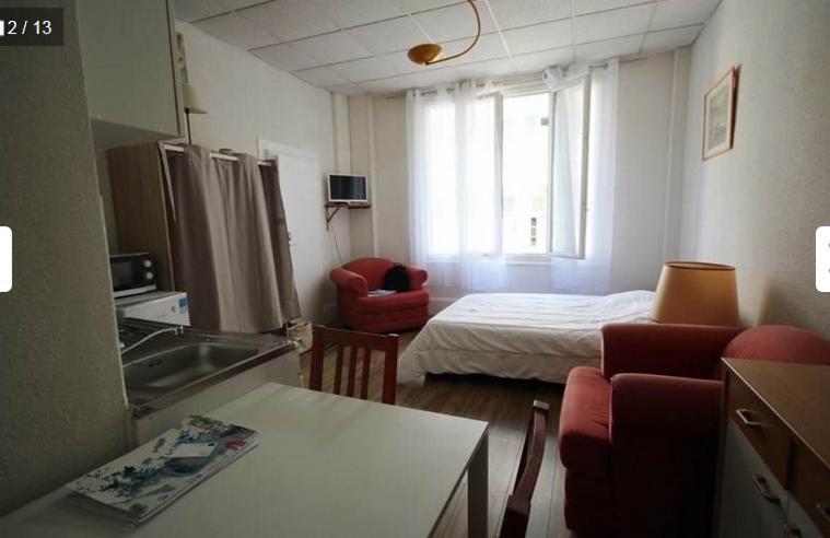Cette petite chambre comprend un lit et une cuisine. dans l'établissement Studio N2 Rez De Chaussée, à Néris-les-Bains