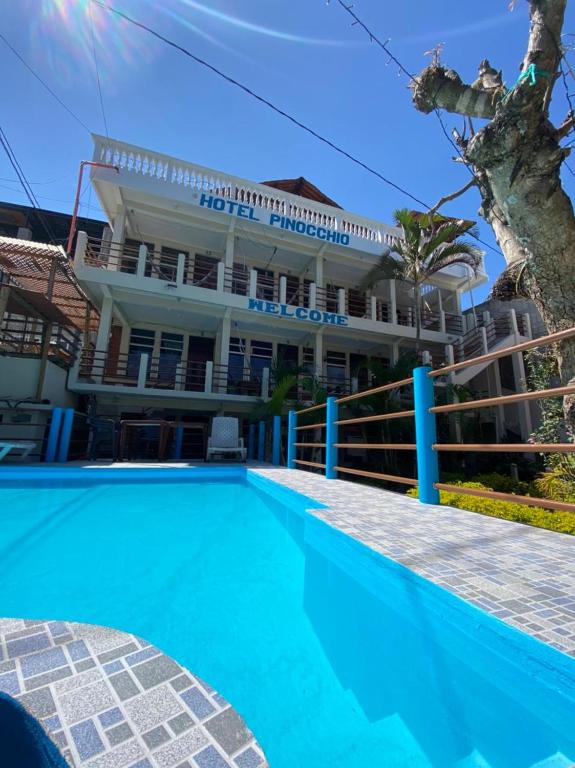 a hotel with a swimming pool in front of a building at Hotel y Restaurante Pinocchio in San Pedro La Laguna