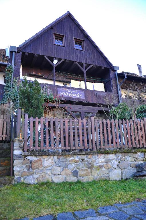 a wooden house with a fence in front of it at Guest House Olšakovský in Český Krumlov
