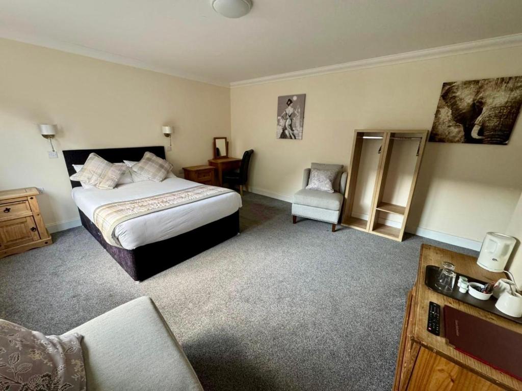 a hotel room with a bed and a chair at The Waverley Inn in Dingwall