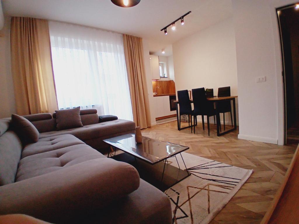a living room with a couch and a dining room at Agoraapartment in Peje
