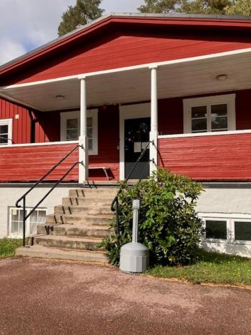 a red and white house with a red roof at Bredsands camping och bad Vandrarhem in Enköping
