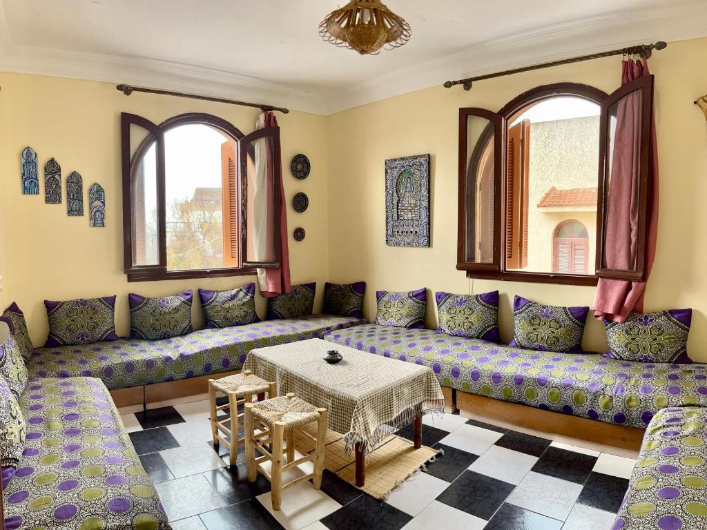 a living room with purple couches and a table at Soleado apartamento al lado de la preciosa medina , a 3 minutos de la playa andando in Asilah