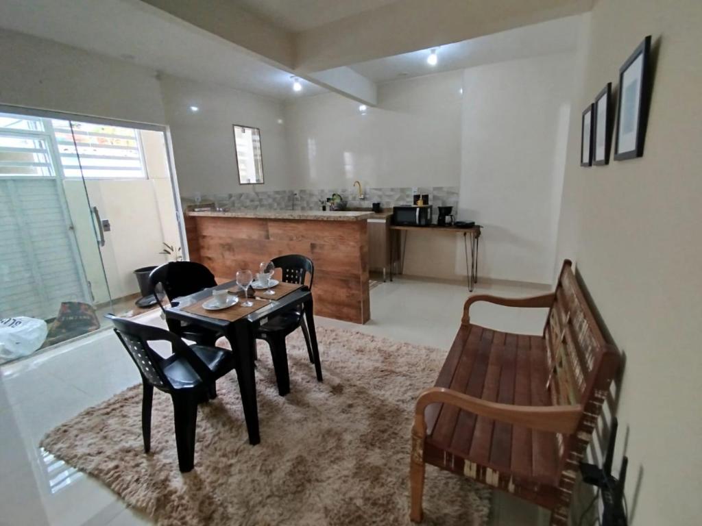 Una sala de estar con mesa y sillas y una cocina. en Loft aconchegante Estou em Arraial, en Arraial do Cabo