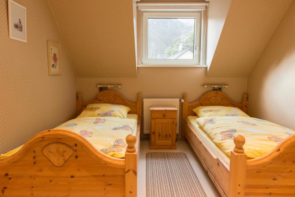 2 aparte bedden in een kleine kamer met een raam bij Ferienwohnung Burg Eltz in Treis-Karden