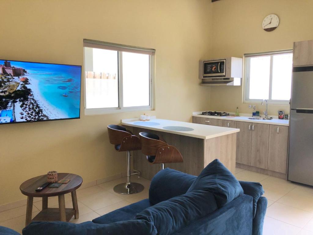 a living room with a couch and a kitchen at Aruba IXORA Suites in Noord