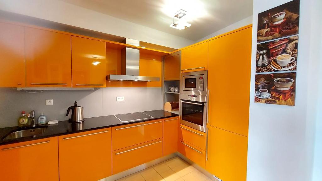 une cuisine avec des armoires orange et un évier dans l'établissement Apartment Orange, à Karlovy Vary