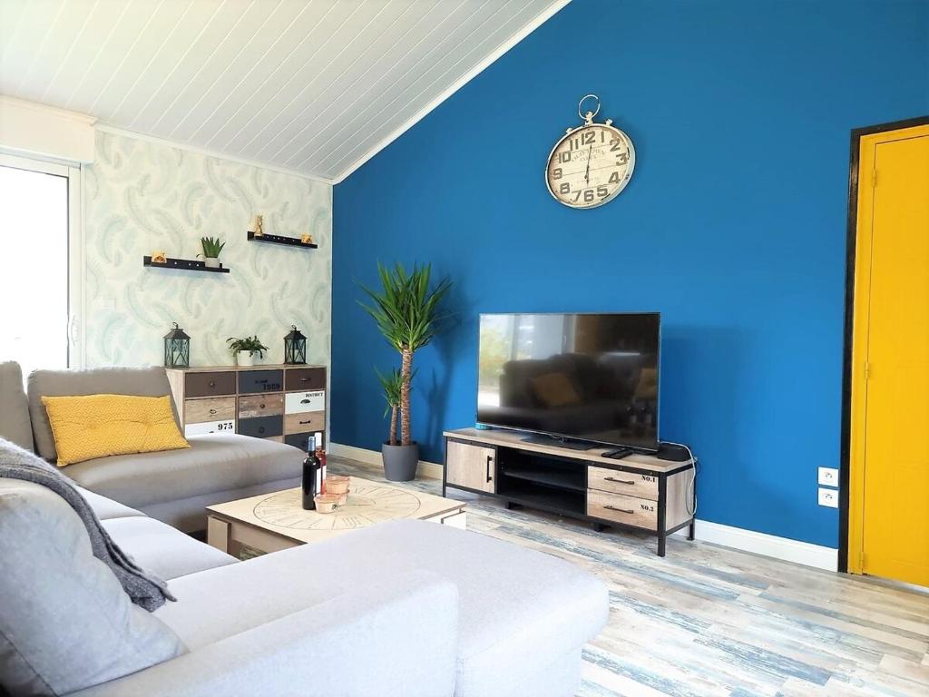 - un salon bleu avec un canapé blanc et une télévision dans l'établissement Villa Familiale near beaches, à Les Sables-dʼOlonne