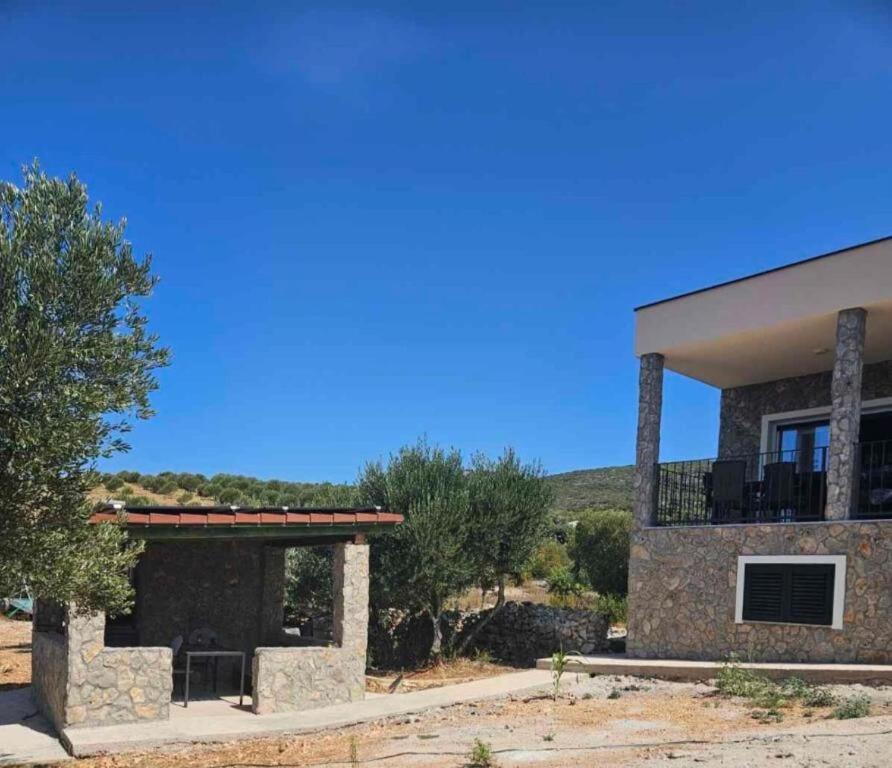 a large stone house with a balcony on top of it at House Sunshine in Mrljane