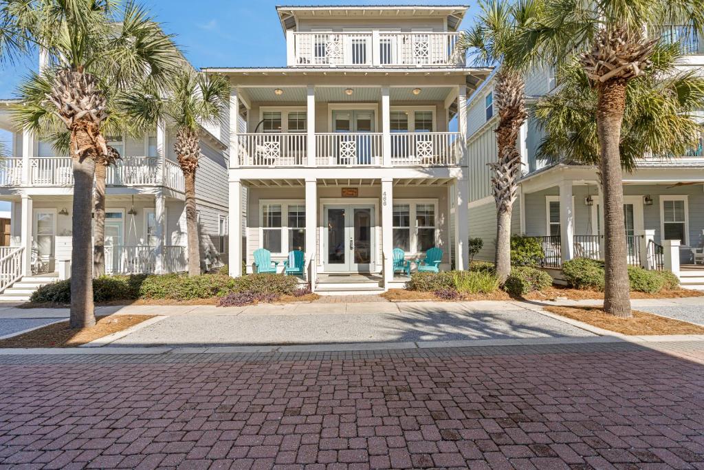 a large white house with palm trees in front of it at Seeking Sunsets 30A in Rosemary Beach