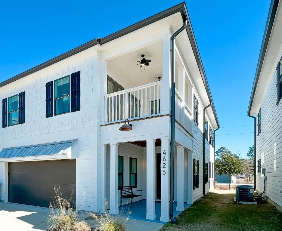 a white house with a balcony and a garage at Endless Summer in Orange Beach