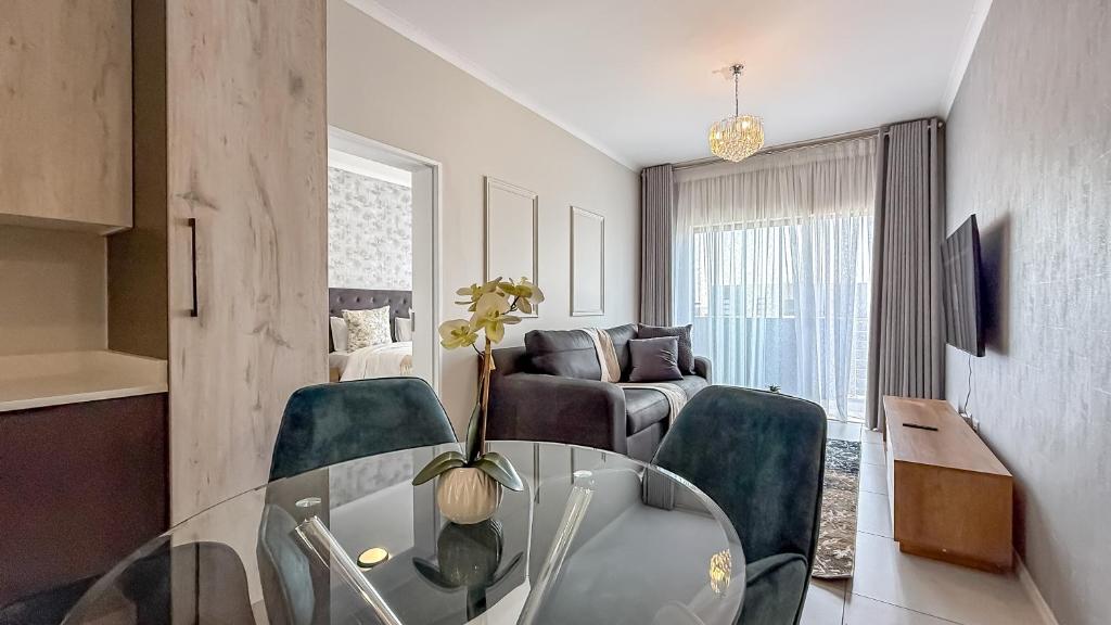 a living room with a glass table and chairs at Binbin Serenity Suite in Midrand