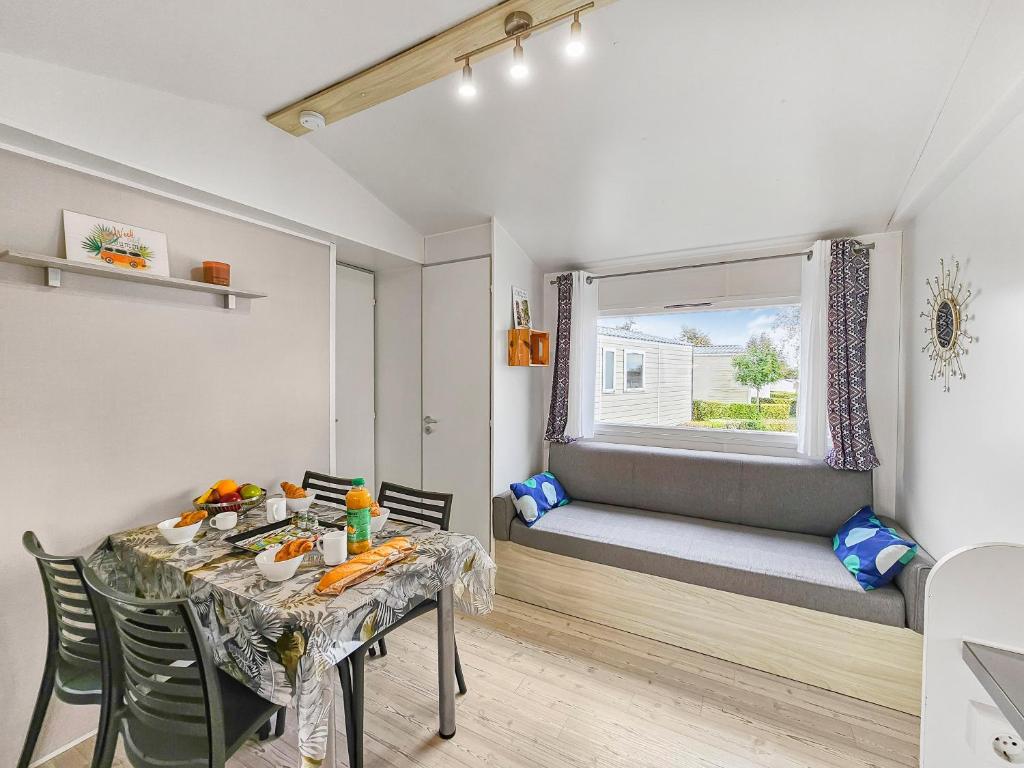 une salle à manger avec une table et une fenêtre dans l'établissement L'Esprit Vintage, terrasse couverte, à Litteau