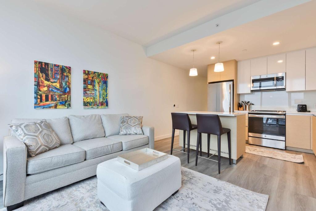 Una sala de estar con un sofá y una cocina. en Luxury Apt Downtown, en Boston