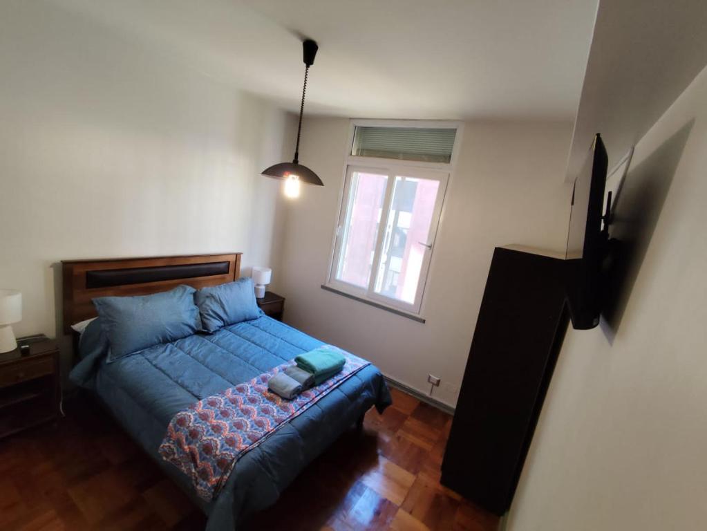 a bedroom with a blue bed and a window at Depto calle huérfanos, Santiago in Santiago