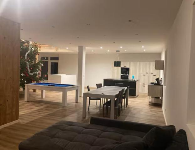 - un salon avec une table de ping-pong et une cuisine dans l'établissement Gîte La Grange, à Germéfontaine