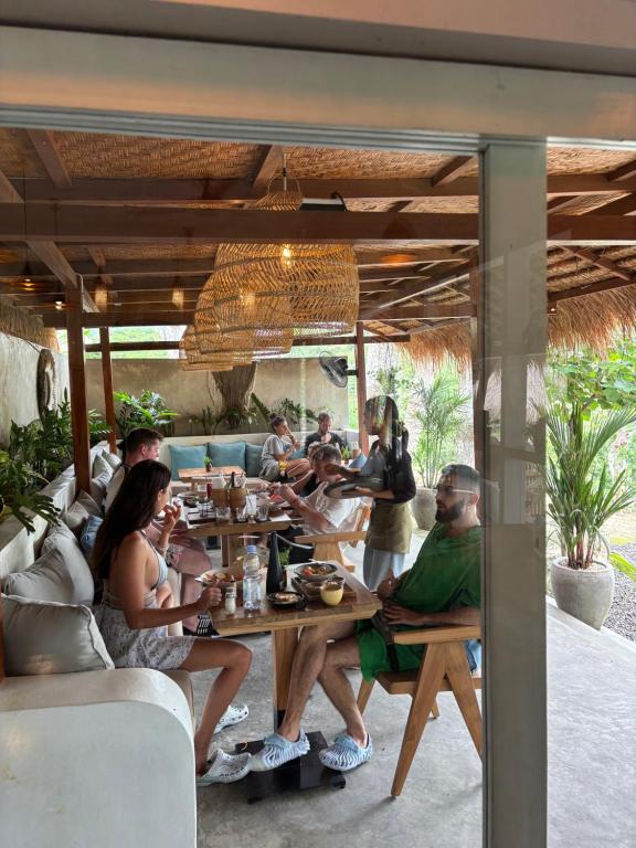 a group of people sitting at a table in a restaurant at kaje cottage & restaurant in Nusa Penida