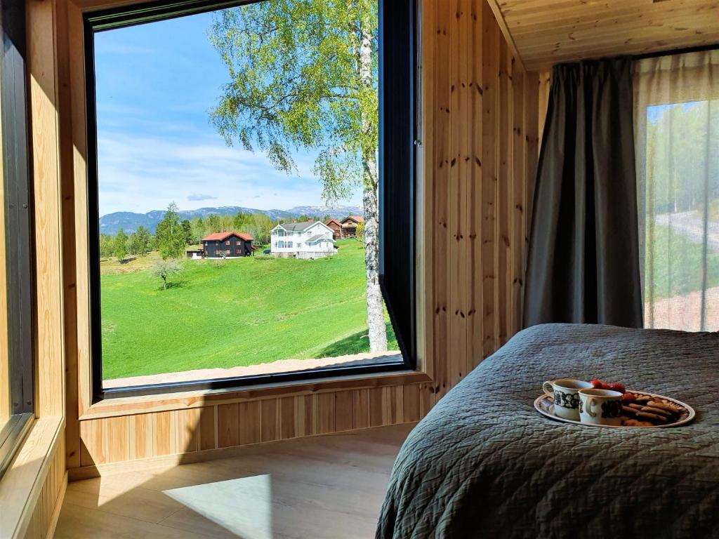 a bed in a room with a large window at Bolkesjø Gaard in Notodden