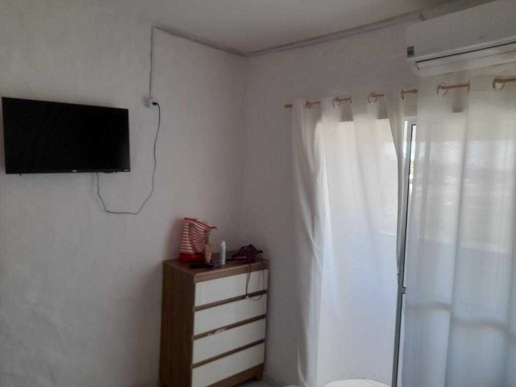 ein Bad mit Dusche und ein TV an der Wand in der Unterkunft Encanto de Tatuamunha in Pôrto de Pedras