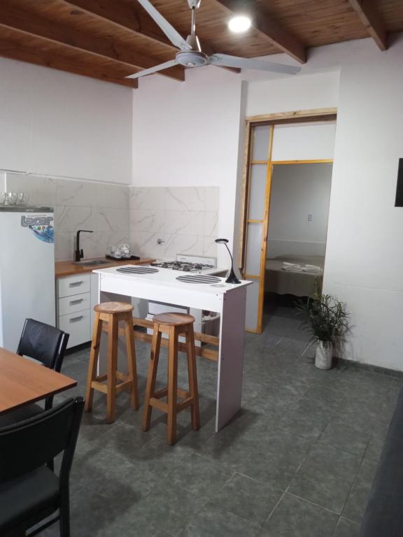 a kitchen with a counter and stools in a room at Casa Silvia in Bahía Blanca