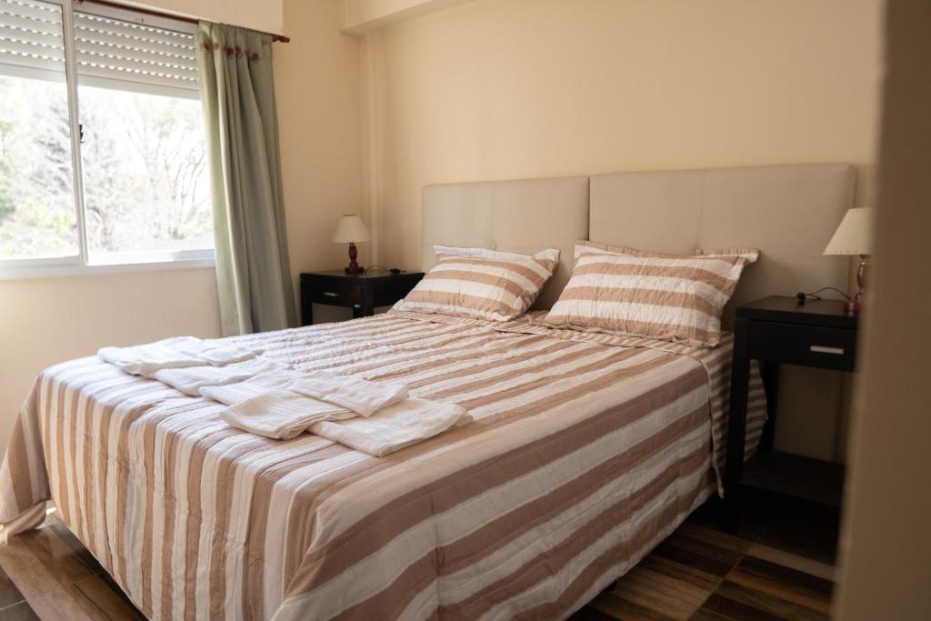 a bedroom with a large bed with towels on it at Cómodo depto en San Nicolás de los Arroyos con cochera 0341-15-675-22-36 in San Nicolás de los Arroyos