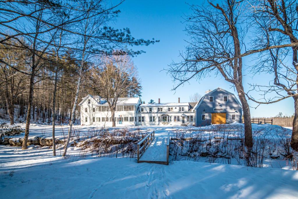 ein großes weißes Haus im Schnee in der Unterkunft Whispering Waters Farmhouse and Wedding Barn in Paris