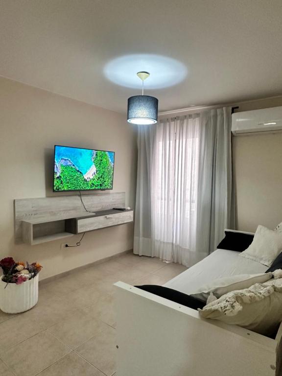 a bedroom with a bed and a flat screen tv at Departamento Premium, Paseo Buen Pastor in Cordoba