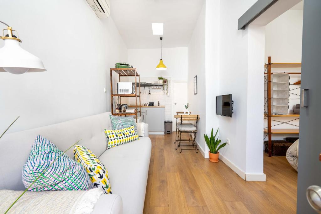 una sala de estar con un sofá blanco con almohadas en Casa Miraya, en Almería