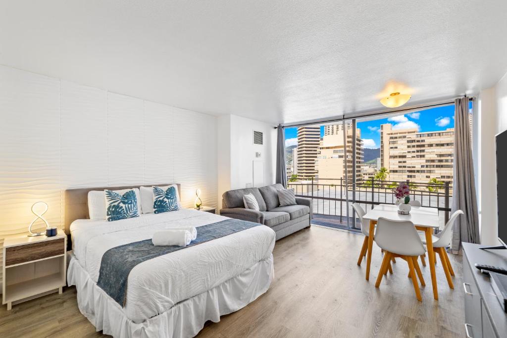 a bedroom with a king sized bed and a balcony at Ilikai Marina Studios in Honolulu