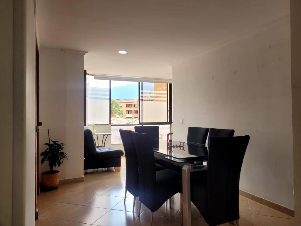 Un comedor con una mesa y sillas negras. en Habitacion Multiple con baño privado, en Medellín