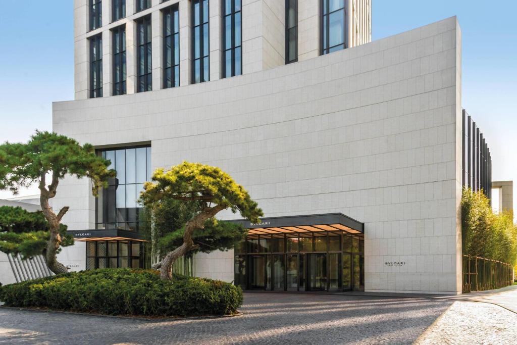 北京北京宝格丽酒店的一栋白色建筑，前面有一棵树