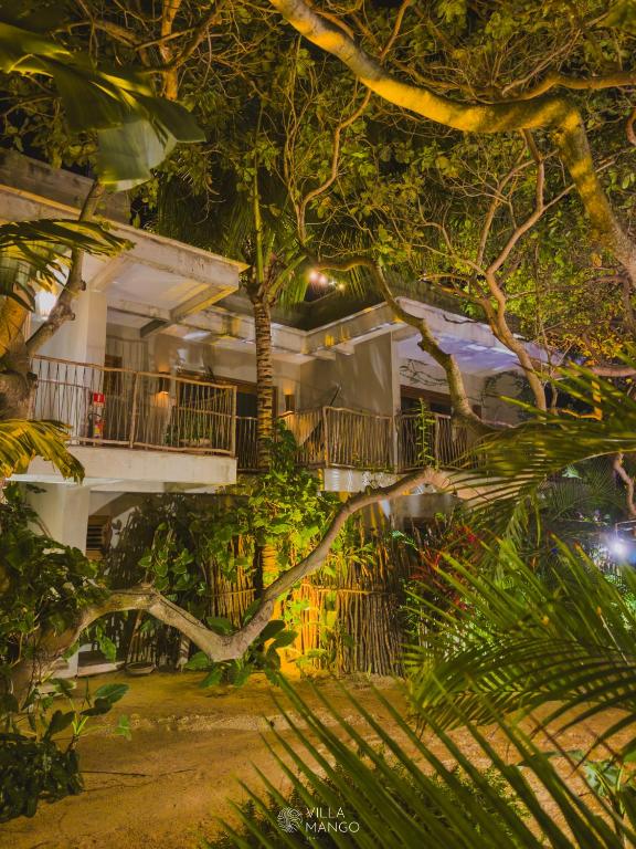 a large white building with a balcony and trees at Villa Mango Jeri in Jericoacoara