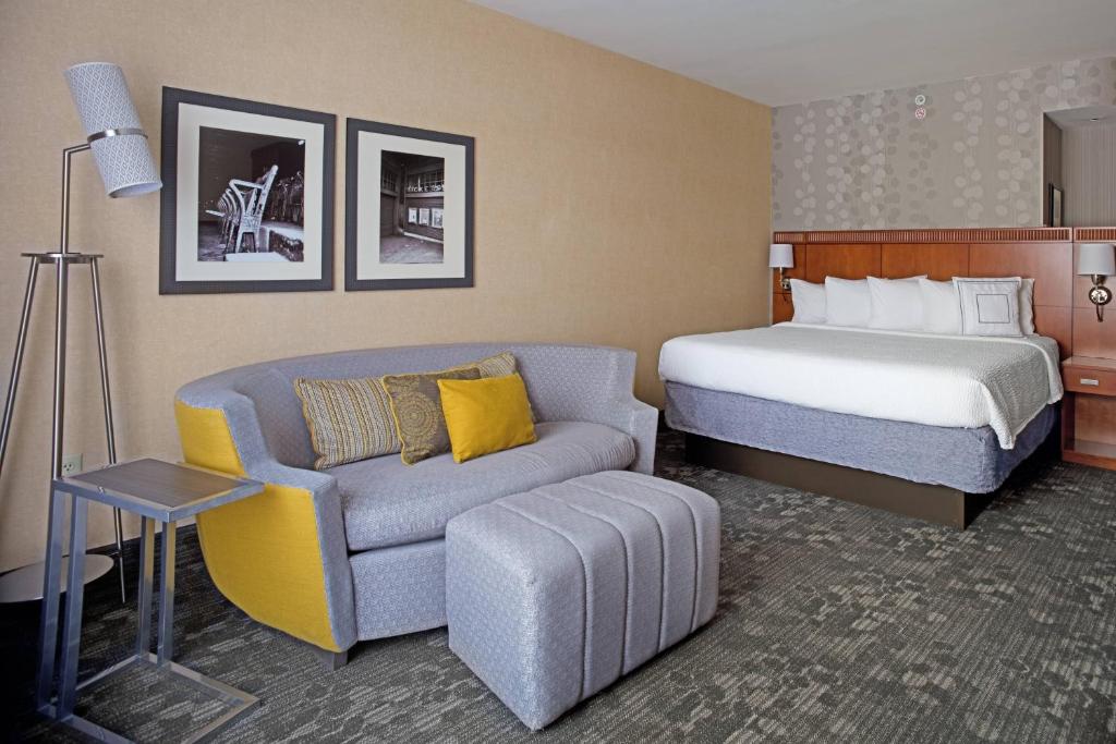 a hotel room with a bed and a couch at Courtyard Aberdeen at Ripken Stadium in Aberdeen