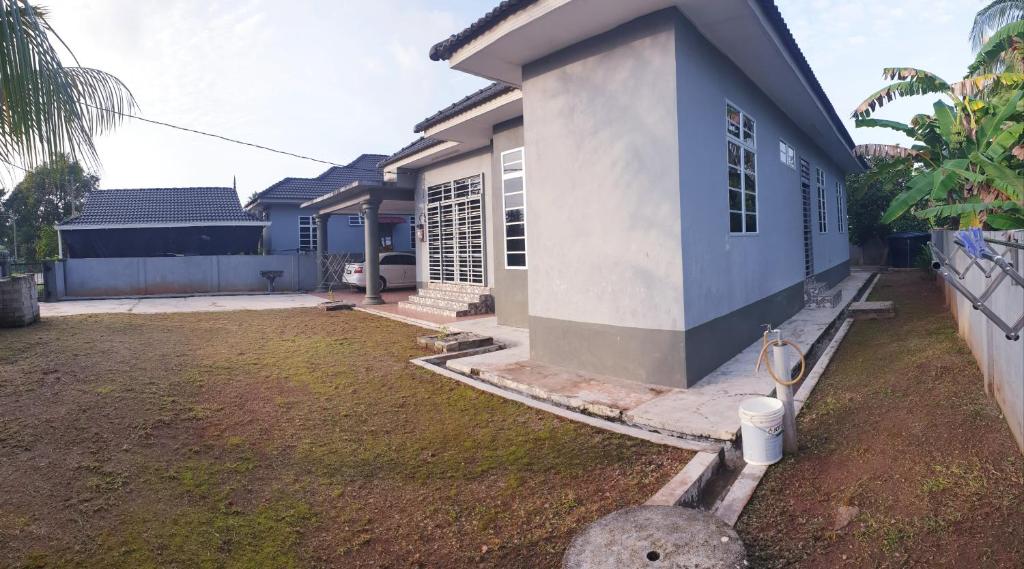 a blue and white house with a yard at Cikteh Homestay Besut in Kampung Raja