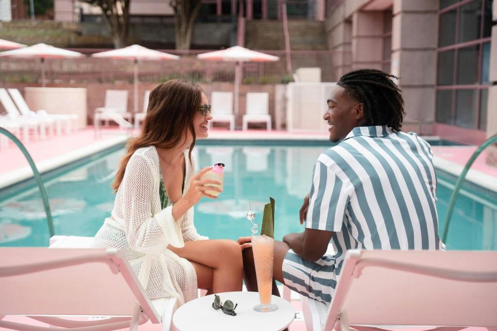 a man and a woman sitting next to a pool at Renaissance Austin Downtown Hotel in Austin