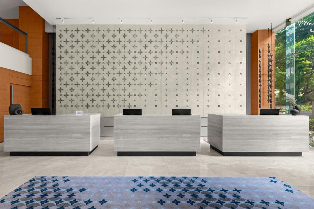 A modern reception desk set against a patterned feature wall.