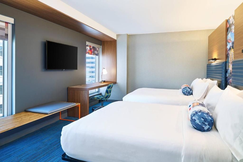 a hotel room with two beds and a desk at Aloft Austin Downtown in Austin