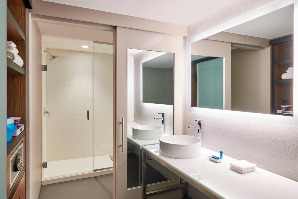 a bathroom with two sinks and two mirrors at Aloft Austin Downtown in Austin